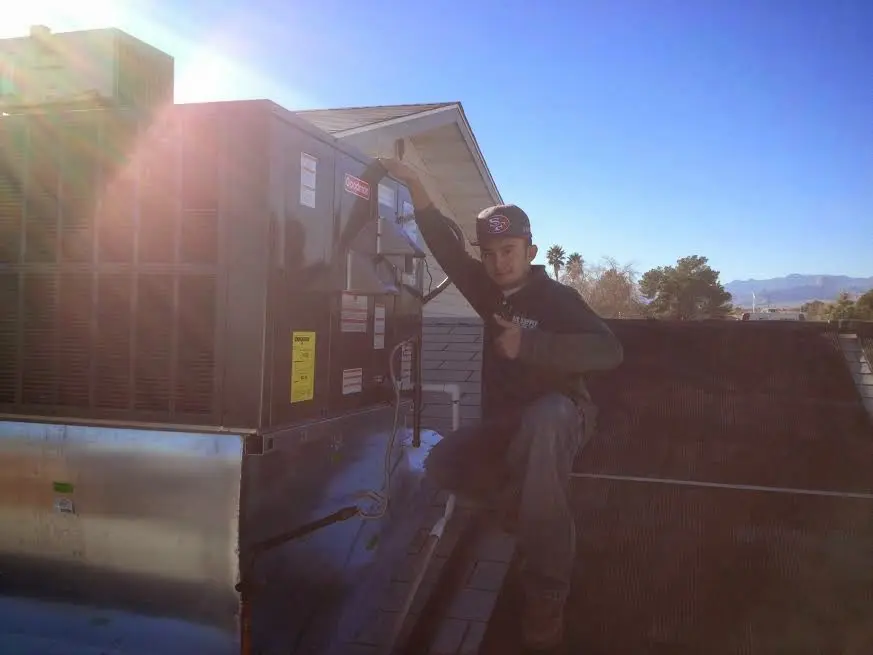 HVAC technician performing AC Tune-Up on a rooftop unit in Anaheim